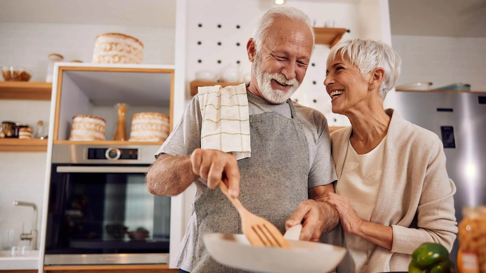 Älteres Ehepaar steht gemeinsam in der Küche