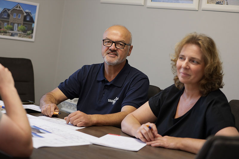 Eine junge Familie sitzt gemeinsam im Wohnzimmer